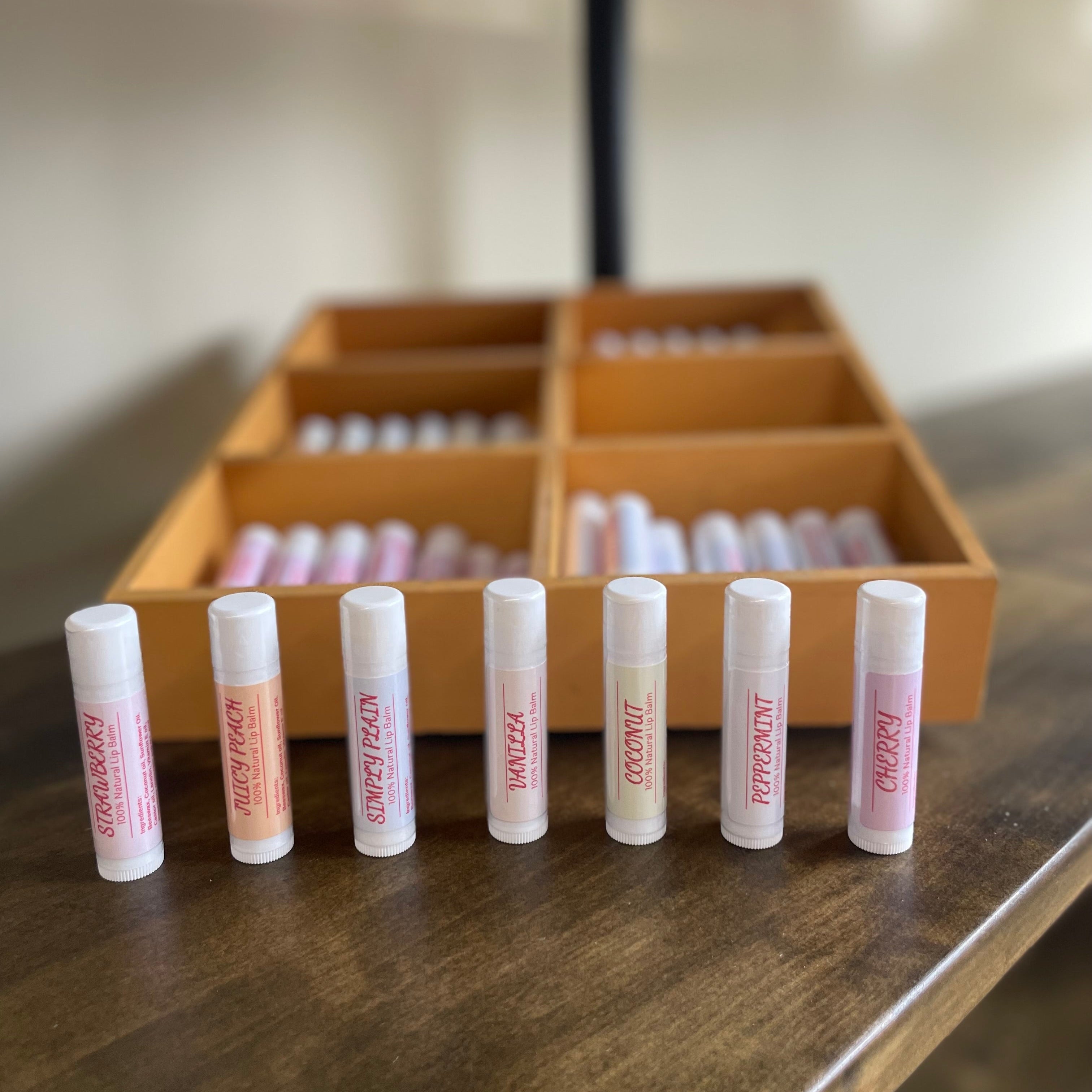 Row of lip balms in front of a display case with more lip balms inside.
